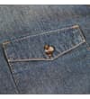 Thumbnail Close-up of chest pocket flap and button on denim shirt.
