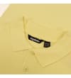 Thumbnail Close-up of yellow polo collar and button placket.